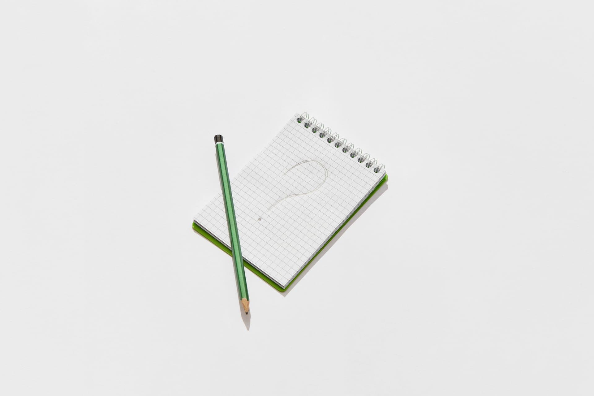 A notebook and pen with question marks
